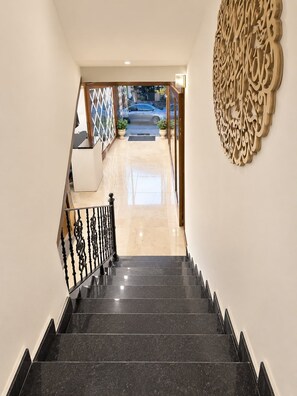 A staircase leading to a lobby with a decorative wall and a view of the street outside. - Sama Al Hamra Furnished Apartments (Beirut)
