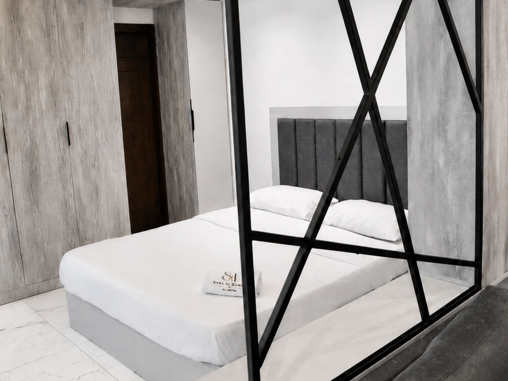 A modern bedroom with a bed, a wardrobe, and a headboard.