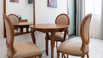 Un comedor con una mesa redonda de madera y cuatro sillas tapizadas.