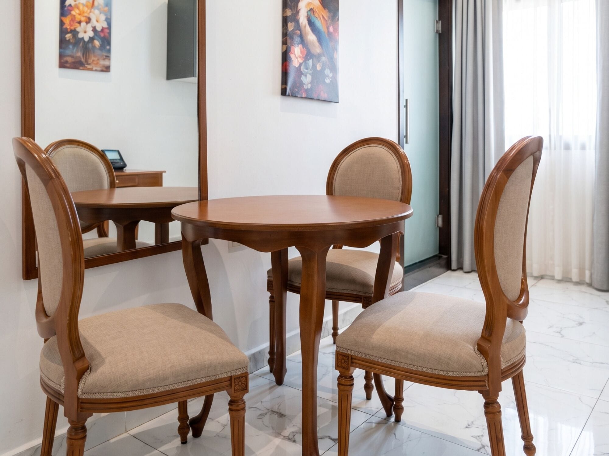 A dining area with a round wooden table and four upholstered chairs.