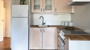 A modern kitchen with a refrigerator, sink, cabinets, and a stove. - 4 Star Holiday Home in Gotlands Tofta (Gotlands Tofta)