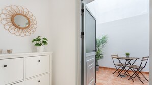 A room with a white dresser, a mirror, a potted plant, a sliding door, and a small table with chairs. - Vacation Apartment 'Nature and Calm Escape' with Mountain View and Wi-Fi (Los Silos)