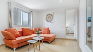 A modern living room with a sofa, a small table, and a potted plant. - Vacation Apartment 'Nature and Calm Escape' with Mountain View and Wi-Fi (Los Silos)
