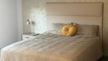 A bedroom with a bed, a nightstand, and a lamp.