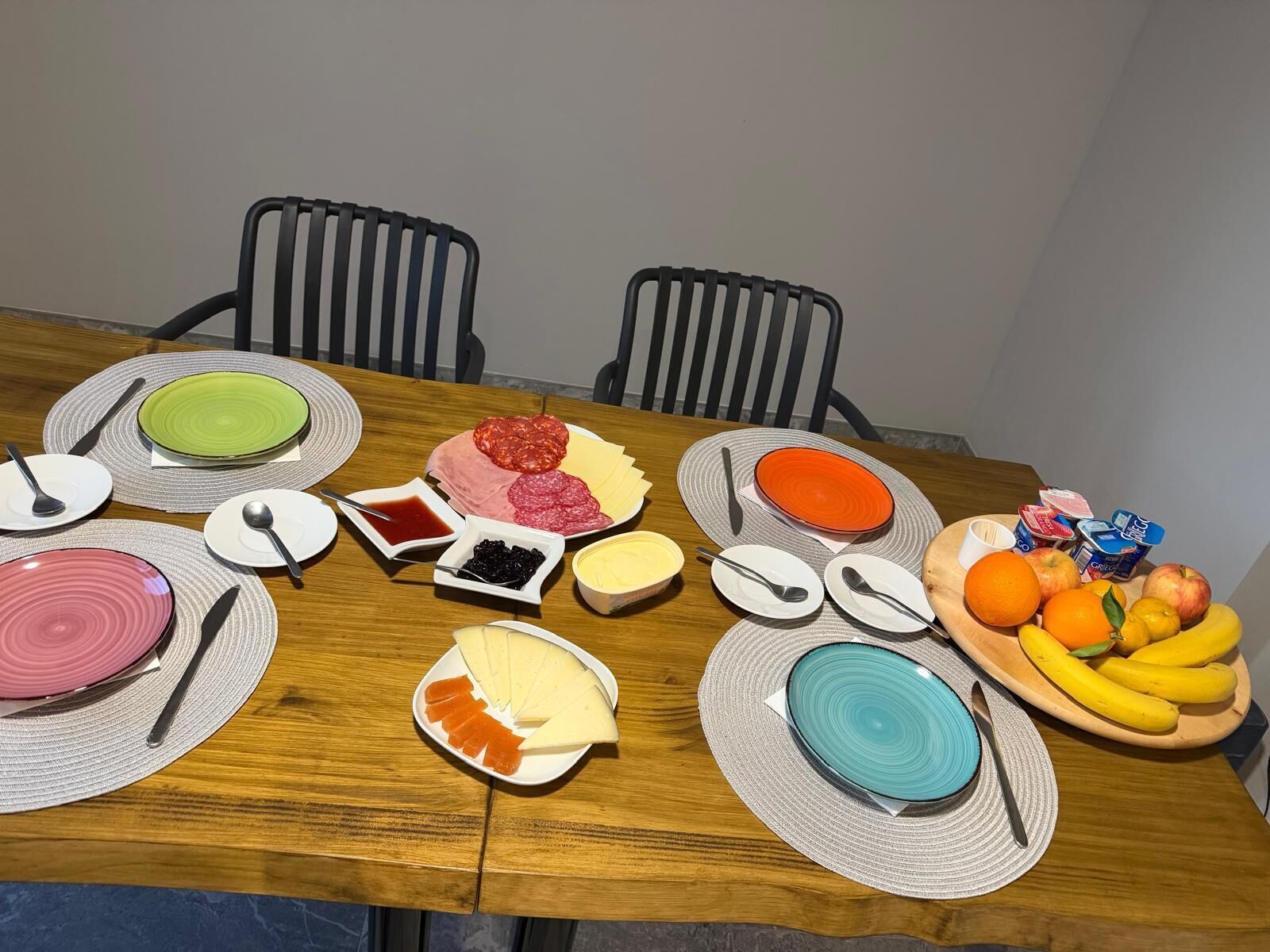 A dining table set with plates, cutlery, and various food items.