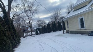 A snow-covered driveway leading to a house with a garage.