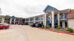 A motel with multiple rooms, a covered parking area, and a fire lane. - Azul Inn Houston Hobby Airport (Houston)