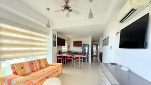 A modern kitchen with a dining area, a sofa, and a TV. - Apartamento 504 vista al mar  (Cartagena)