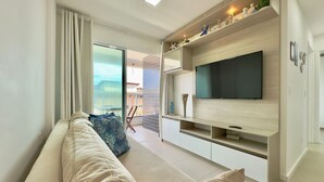 Una sala de estar moderna con sofá, televisor y estanterías.