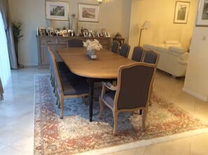 Un coin repas avec une table en bois, six chaises et un centre de table floral.