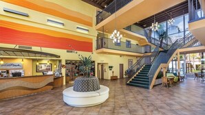 A spacious lobby with a central seating area, a staircase, and a reception desk. - Palm Springs | Relaxing Desert Escape | Pool + Hot Tub (Palm Springs)