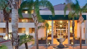 A hotel with a central courtyard, palm trees, and a fountain. - Palm Springs | Relaxing Desert Escape | Pool + Hot Tub (Palm Springs)