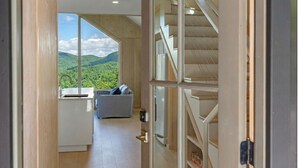 A modern interior with a view of a mountainous landscape through large windows.