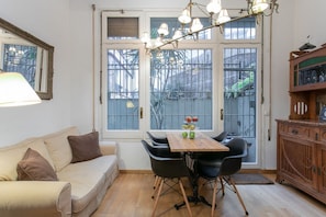 A cozy room with a wooden table, black chairs, a beige sofa, and a wooden cabinet. - Spacious & Luxury Apartment /Center (08037 Barcelona)