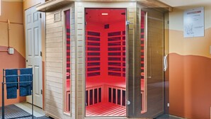 Une salle de sauna avec une porte en bois, un porte-serviettes et un panneau sur le mur.