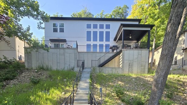 A wooden pathway leading to a modern building with large windows and a covered area.