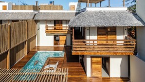Eine moderne Villa mit Schwimmbad, Holzterrasse und Balkon mit Blick auf das Schwimmbecken.