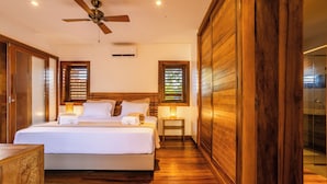 Ein Schlafzimmer mit einem großen Bett, Holzwänden und einem Deckenventilator.