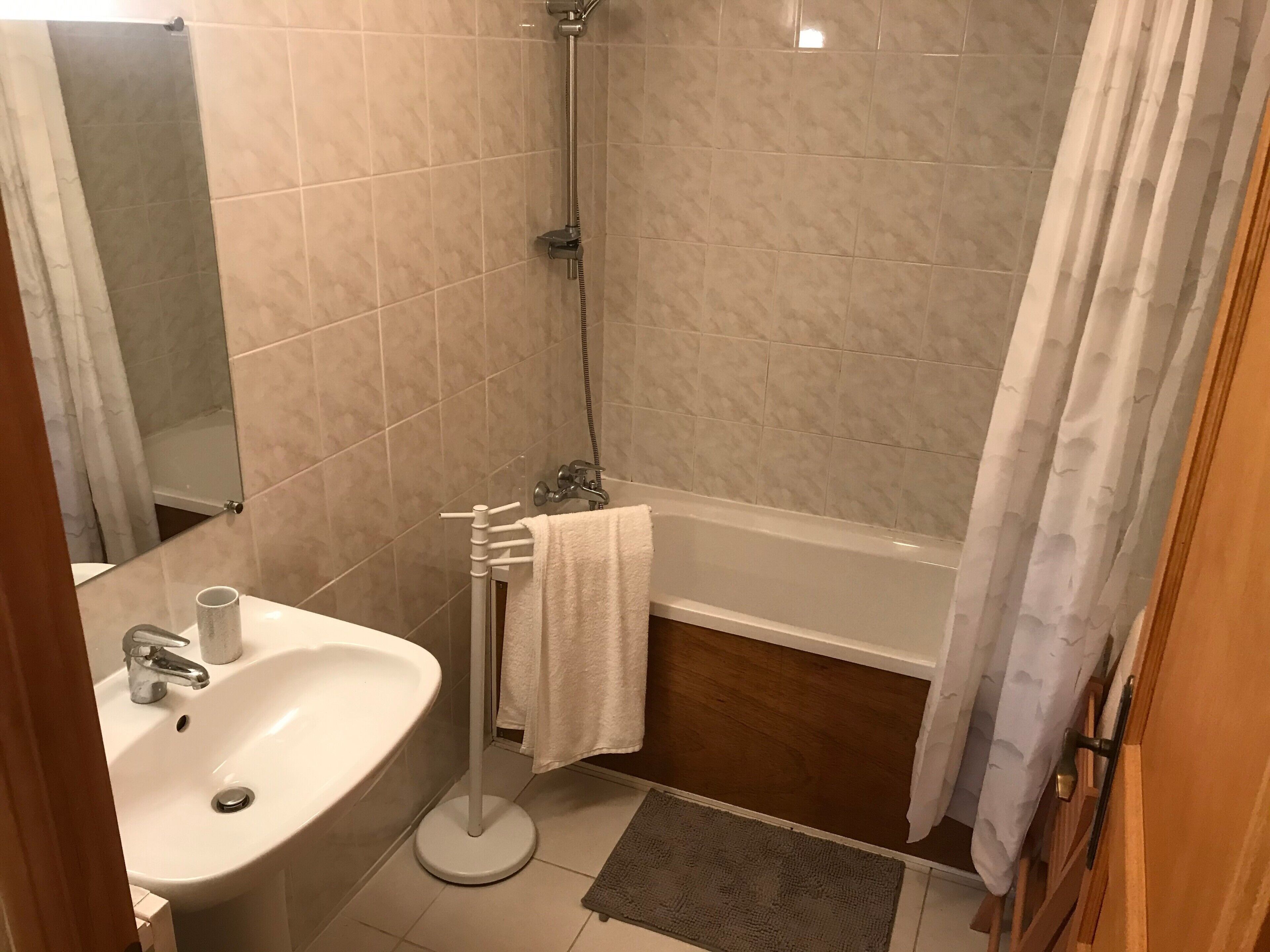 A bathroom with a sink, mirror, shower, and bathtub.