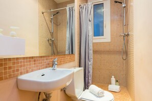 Een douche, een bidet, handdoeken, shampoo