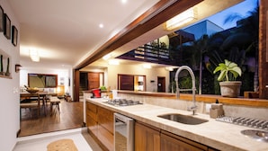 A modern kitchen with wooden cabinets, a stainless steel sink, and a built-in dishwasher.