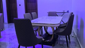 A conference room with a marble floor, a round table, and modern chairs. - Spacious 3-bedroom apartment with AC in gorgeous Lagos (Lagos)