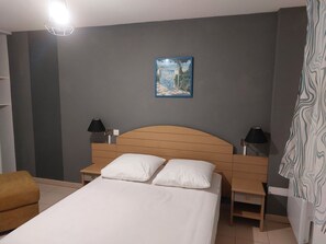 A hotel room with a bed, two bedside tables with lamps, a nightstand, a chair, and a painting on the wall. - Nice apartment - near sea - 6pers (Ondres)