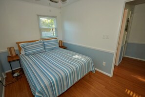 Ein Schlafzimmer mit Bett, Fenster und Tür.