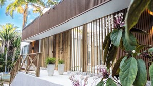 A modern building with a wooden facade, a concrete staircase, and potted plants.