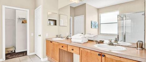 A bathroom with two sinks, wooden cabinets, and a large mirror.