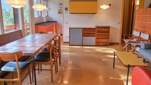Una cocina moderna con armarios de madera, refrigerador empotrado y luces colgantes.