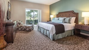 A bedroom with a bed, nightstands, a desk, a chair, and a view through a sliding glass door. - Sonoma | Vineyard Getaway & Outdoors | Pool | 2BR Twin (Windsor)