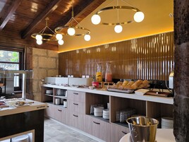 Una cocina moderna con armarios de madera, una encimera con productos para el desayuno y una lámpara colgante.