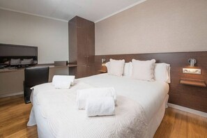 A hotel room with a large bed, a flat-screen TV, a wooden wardrobe, and a bedside table with a lamp. - AMAZING Plaza Catalunya & Paseo de Gracia (08007 Barcelona)