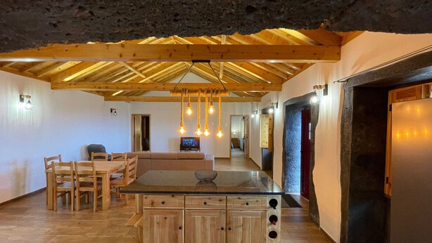 Een moderne keuken met houten kasten, een centraal eiland en hangende吊灯.