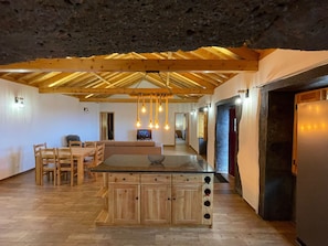 Uma cozinha ampla com armários de madeira, uma ilha central e luminárias pendentes.