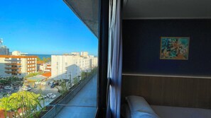 A view from a balcony with a clear sky, a painting on the wall, and buildings in the background. - Condomínio Acqua Tambaú - By Almare (João Pessoa)