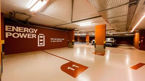 Eine Parkgarage mit der Beschilderung 'ENERGY POWER', deutlich markiertem Boden und einem Fahrzeug im Hintergrund.