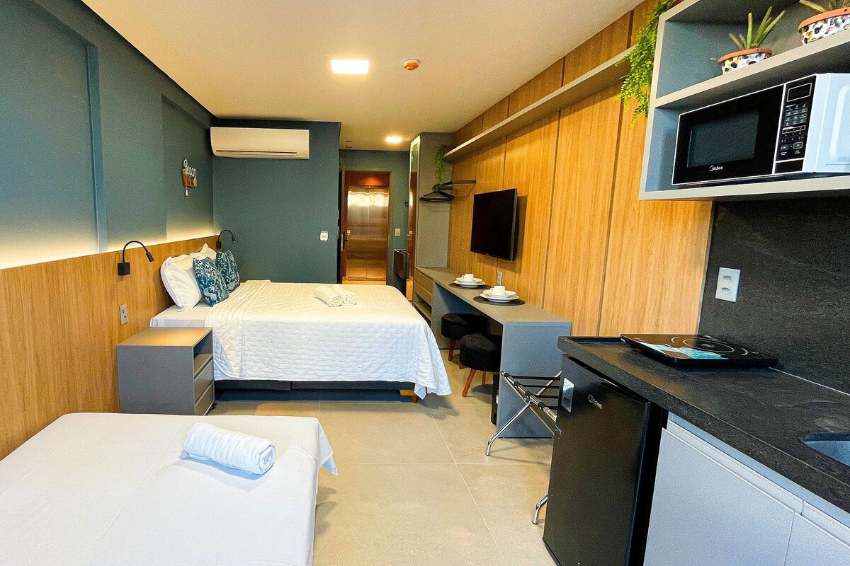 Habitación de hotel con dos camas, kitchenette, televisión de pantalla plana y un pequeño comedor.