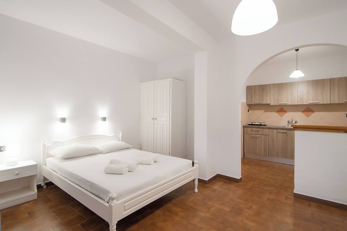 A bedroom with a bed, bedside table, and a wardrobe.