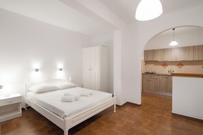 A bedroom with a bed, bedside table, and a wardrobe.