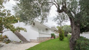 Une maison moderne avec un escalier en pierre, une façade blanche et une pelouse bien entretenue.