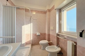 A bathroom with a shower, toilet, bidet, and a window. - Bright B&B with Sea View Balcony - 103 - Santangelo - Pool (Monte Sant'Angelo)