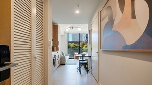 Un couloir moderne comprenant un coin cuisine, un espace repas et une grande fenêtre donnant sur la ville.