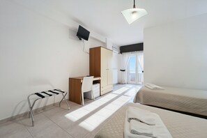 A hotel room with a desk, two beds, a chair, a TV, and a window with curtains. - B&B Sea View with Balcony - 104 - Santangelo - Pool (Monte Sant'Angelo)