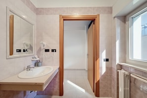 Un baño moderno con lavamanos, espejo y barra para toallas.