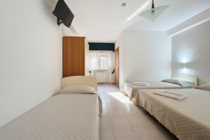 A hotel room with two beds, a window with curtains, a radiator, and a ceiling light. - B&B with Window - 108 - Santangelo - Pool (Monte Sant'Angelo)