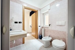 A modern bathroom with a sink, toilet, bidet, and a hairdryer on the wall. - B&B with Window - 108 - Santangelo - Pool (Monte Sant'Angelo)