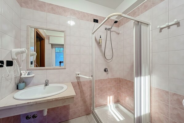 A bathroom with a sink, mirror, hairdryer, and shower. - B&B with Window - 107 - Santangelo - Pool (Monte Sant'Angelo)