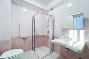 Un bagno con doccia, servizi igienici, lavandino e specchio.